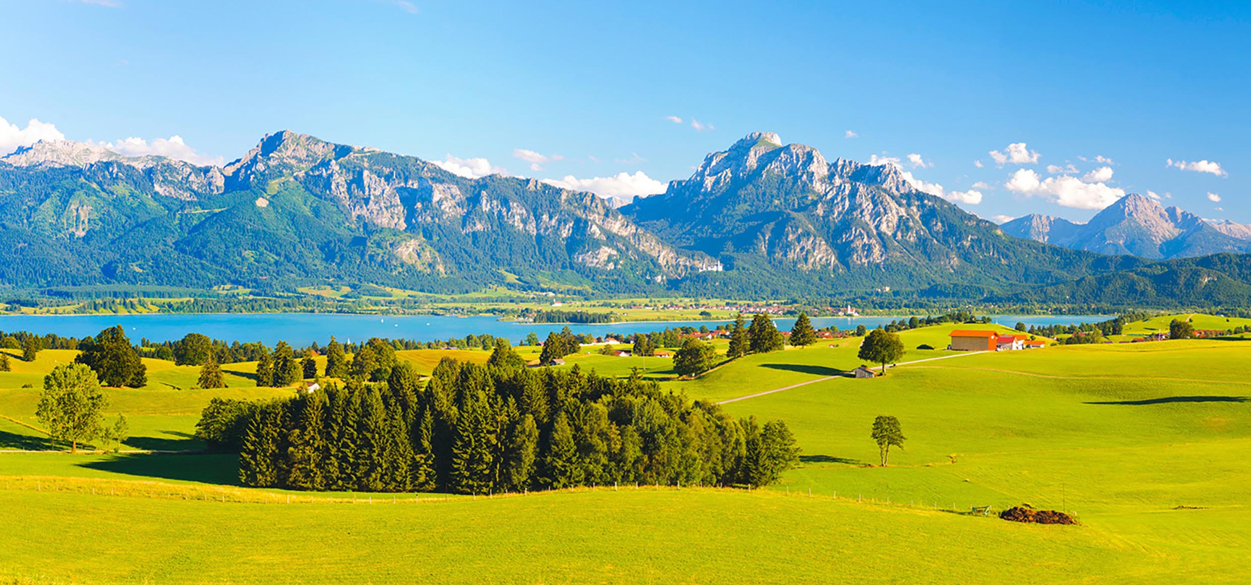 Panorama Landschaft in Bayern am Forggensee mit Blick auf die Alpenkette mit Berg Säuling, dem Hausberg der Stadt Füssen
